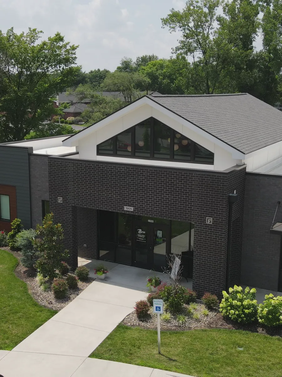 The clubhouse at The Bend with landscaped beds and lawn